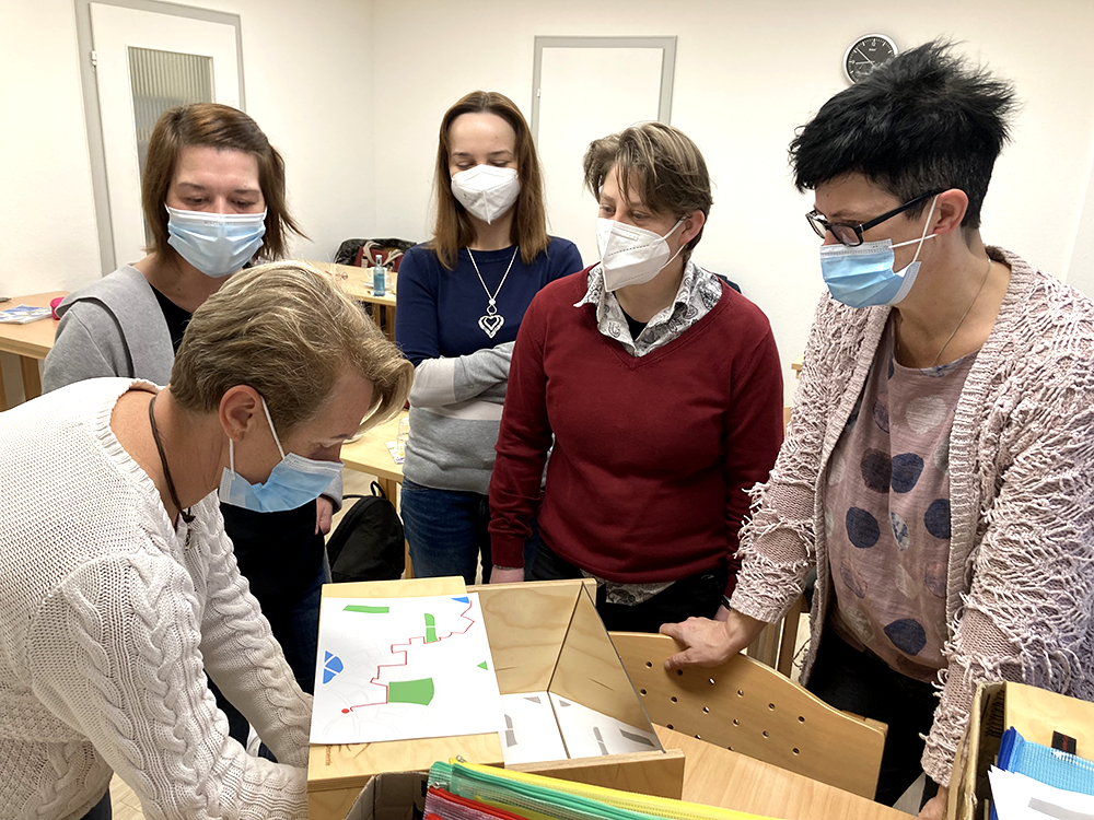 Teilnehmende der Weiterbildung zur gerontopsychiatrischen Fachkraft probieren sich am Demenz-Simulator aus